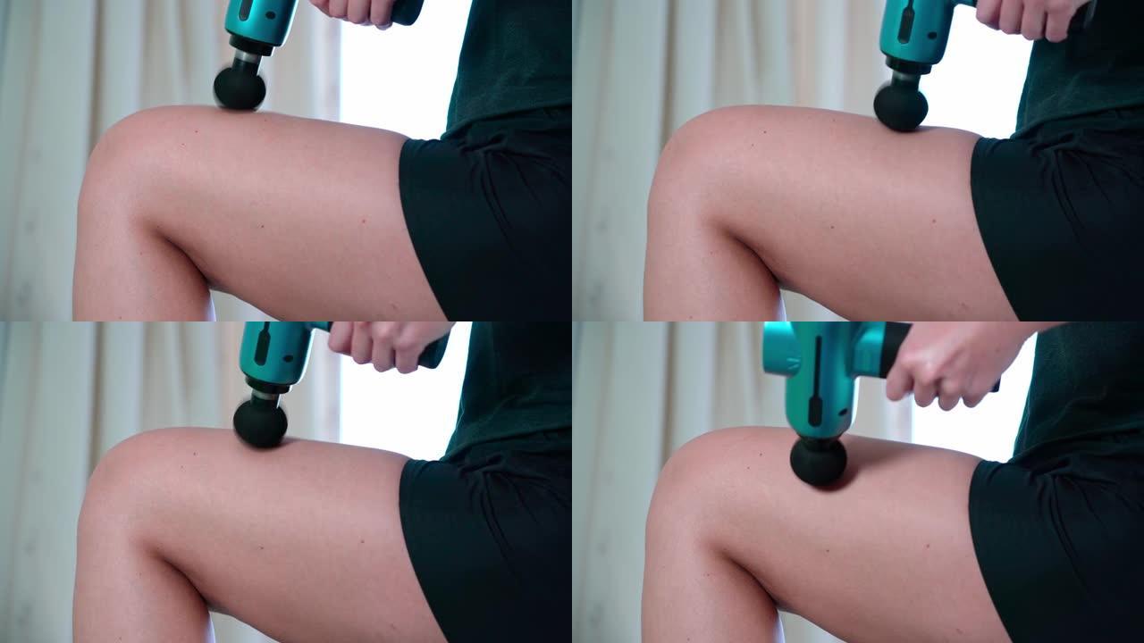这位女运动员使用现代按摩枪治疗大腿放松和对抗脂肪团。训练和复兴后运动恢复的概念。