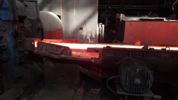 热坯在冶金车间，金属生产，钢铁车间的辊子上移动。轧钢冶金厂。供应轧制金属产品