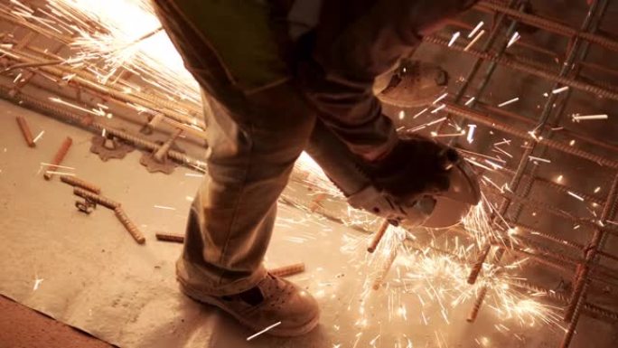 工业专业工人正在用圆锯切割金属钢筋。建造一个工厂，机库
