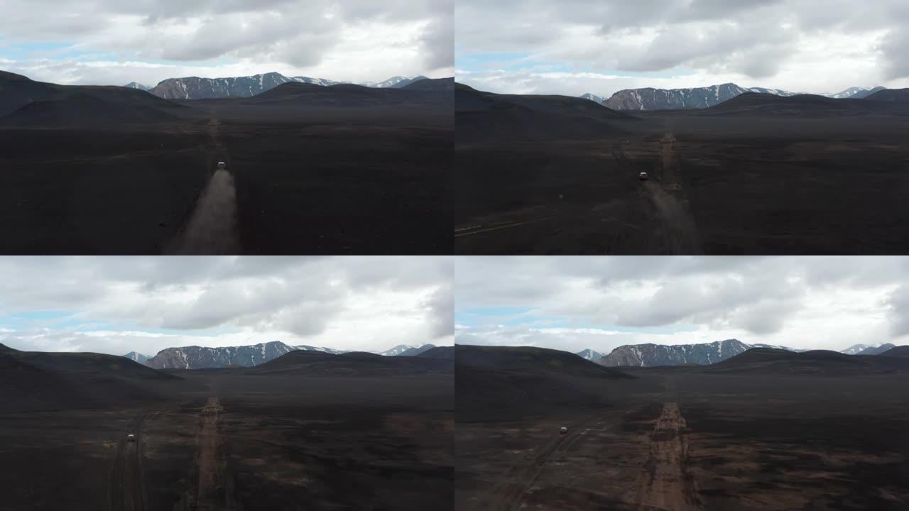 斯卡夫塔费尔国家公园Lakagigar黑色火山沙漠的鸟瞰图，汽车搅动着尘埃云驶出道路。无人机视图4x