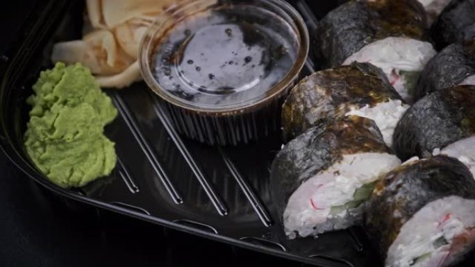 塑料盒中的日本寿司卷正在旋转