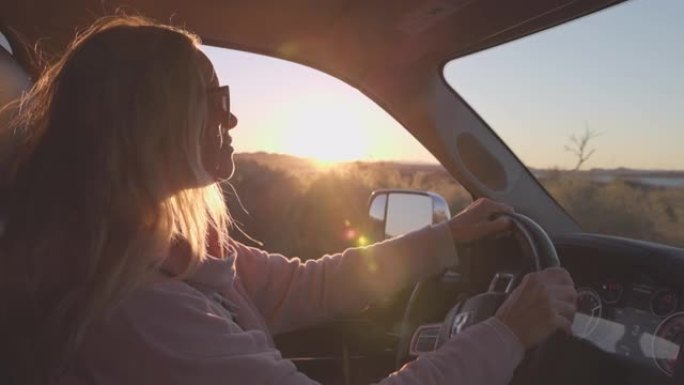 成熟的女人沿着乡村道路开车