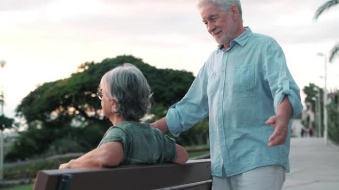 头像特写肖像快乐的白发中年妇女依偎在微笑的老丈夫身边，在公园享受温柔的时刻。相爱的老家庭夫妇拥抱，感