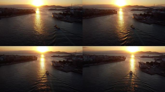 日落时离开雅典比雷埃夫斯港的一艘小驳船的无人机视图。