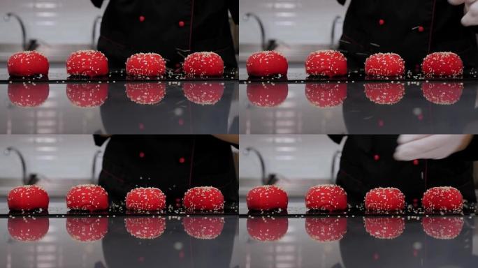 一位女糕点厨师用红镜釉装饰慕斯蛋糕的特写镜头。