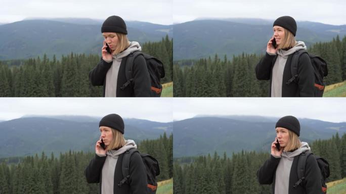 一位年轻的游客站在山顶上，用手机打电话。复制空间。