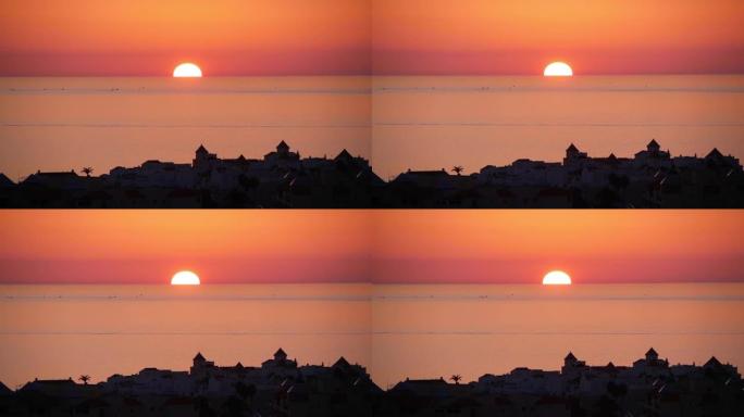 太阳落山在地平线和海边的欧洲老城
