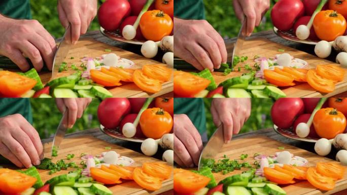 在户外做蔬菜沙拉。库克切西红柿，黄瓜，蔬菜，洋葱，橄榄油的沙拉。健康膳食和营养概念。用刀用新鲜生蔬菜