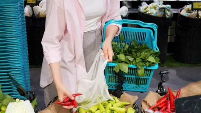 女人在当地生态市场上从货架上选择新鲜蔬菜的电影镜头。当地农民种植的新鲜蔬菜农产品交易会。有机蔬菜种植