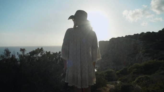 2个剪辑!一个年轻漂亮的女人，穿着自由自在的衣服和一顶帽子凝视着大海。梅诺卡岛-西班牙4K