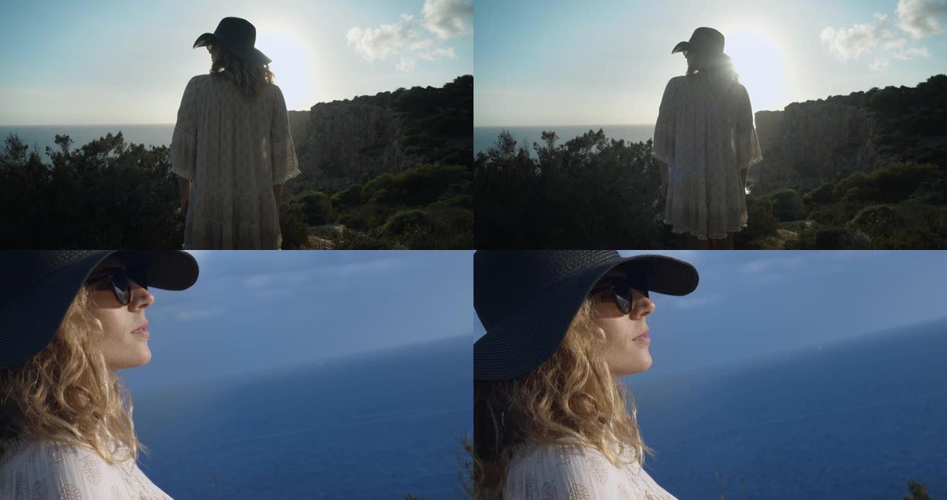 2个剪辑!一个年轻漂亮的女人，穿着自由自在的衣服和一顶帽子凝视着大海。梅诺卡岛-西班牙4K