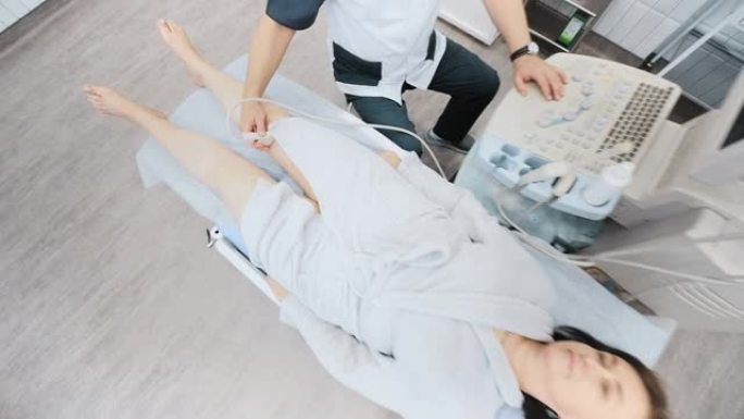 医生对病人腿上的静脉做超声波检查。在现代诊所中，一名静脉医师用超声仪检查妇女腿上的静脉。