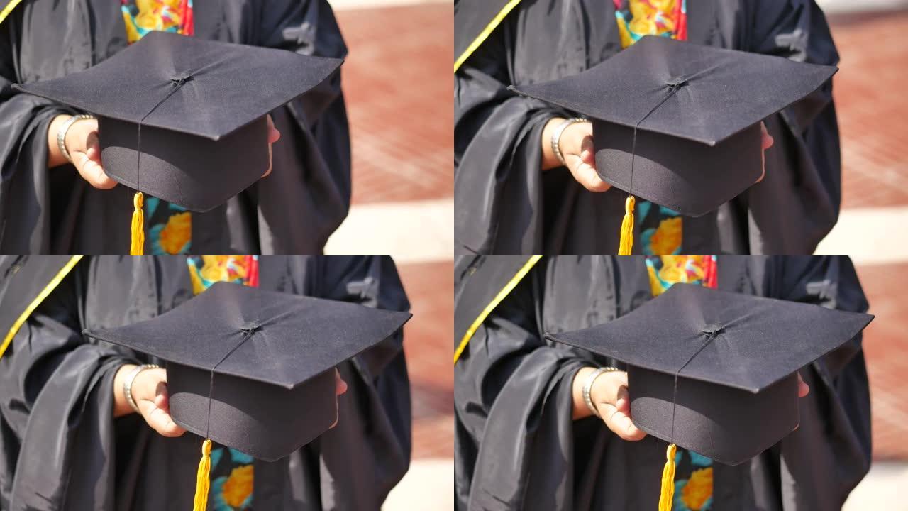 学生在黄色背景的毕业典礼上手持帽子