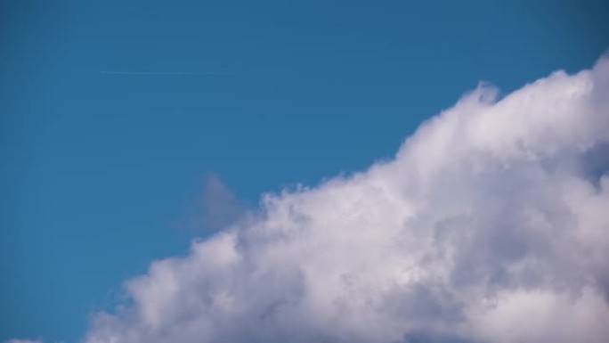 遥远的客机在蓝天上高空飞行，白云在后面留下了轨迹的烟雾痕迹。航空旅行概念
