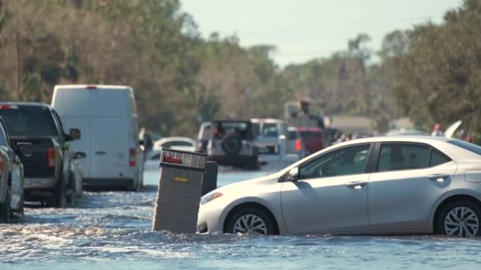 在佛罗里达州居民区，用被水包围的移动车辆淹没了美国街。飓风伊恩自然灾害的后果