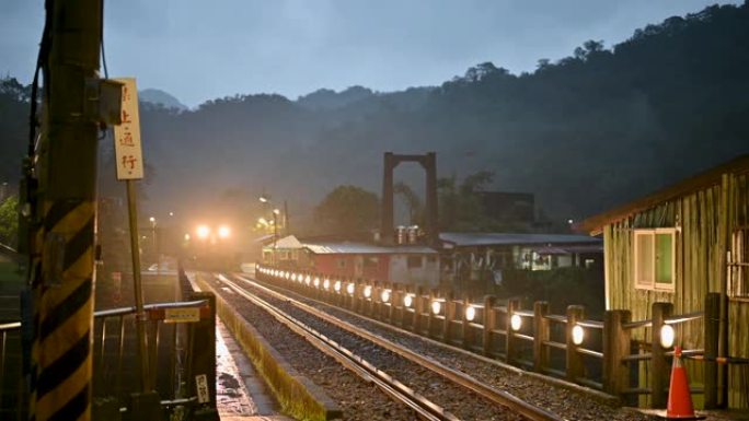 下雨了。火车开着灯在山间穿行。