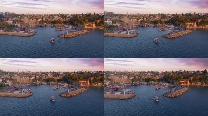 一艘驶入海湾的旅游船的无人机上的航拍录像。港。背景中的历史名城。