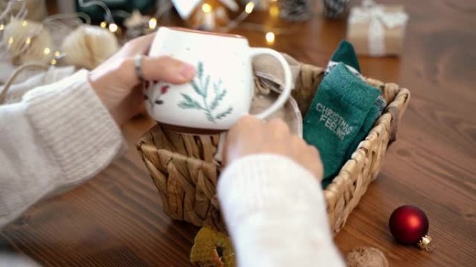 女人的手包裹圣诞生态礼品篮，特写。木制桌子上没有准备好的礼物，带有自然装饰元素和物品圣诞节或新年DI