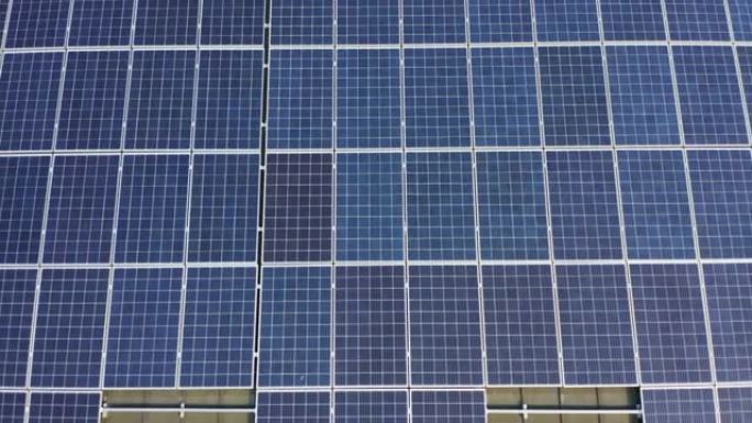 从太阳鸟瞰图看，安装在屋顶上的蓝色太阳能电池板的特写镜头，用于可再生能源。太阳能电池板移动镜头。太阳