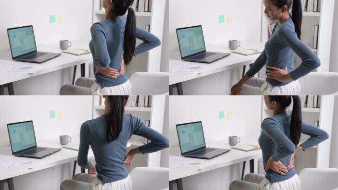 年轻的亚洲女商人在工作时背部疼痛。办公室综合症概念。