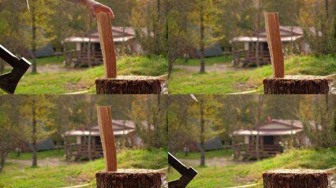 一个男人在房子的后院用斧头砍柴的特写镜头。