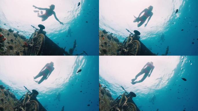 年轻女子在马尔代夫清澈的水中在沉船上游泳和浮潜，并经过相机