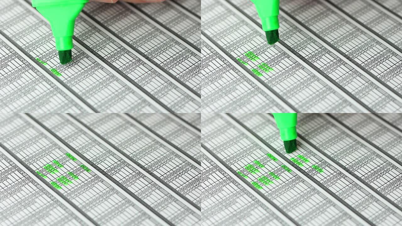 手用记号笔在一份财务会计文件上高亮。