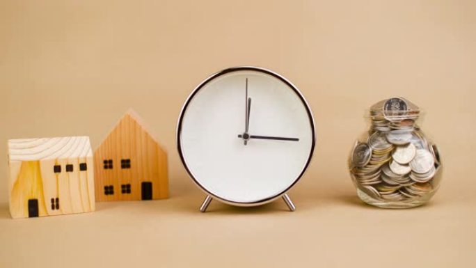 闹钟。白色快速转动时间概念，木屋和储蓄。