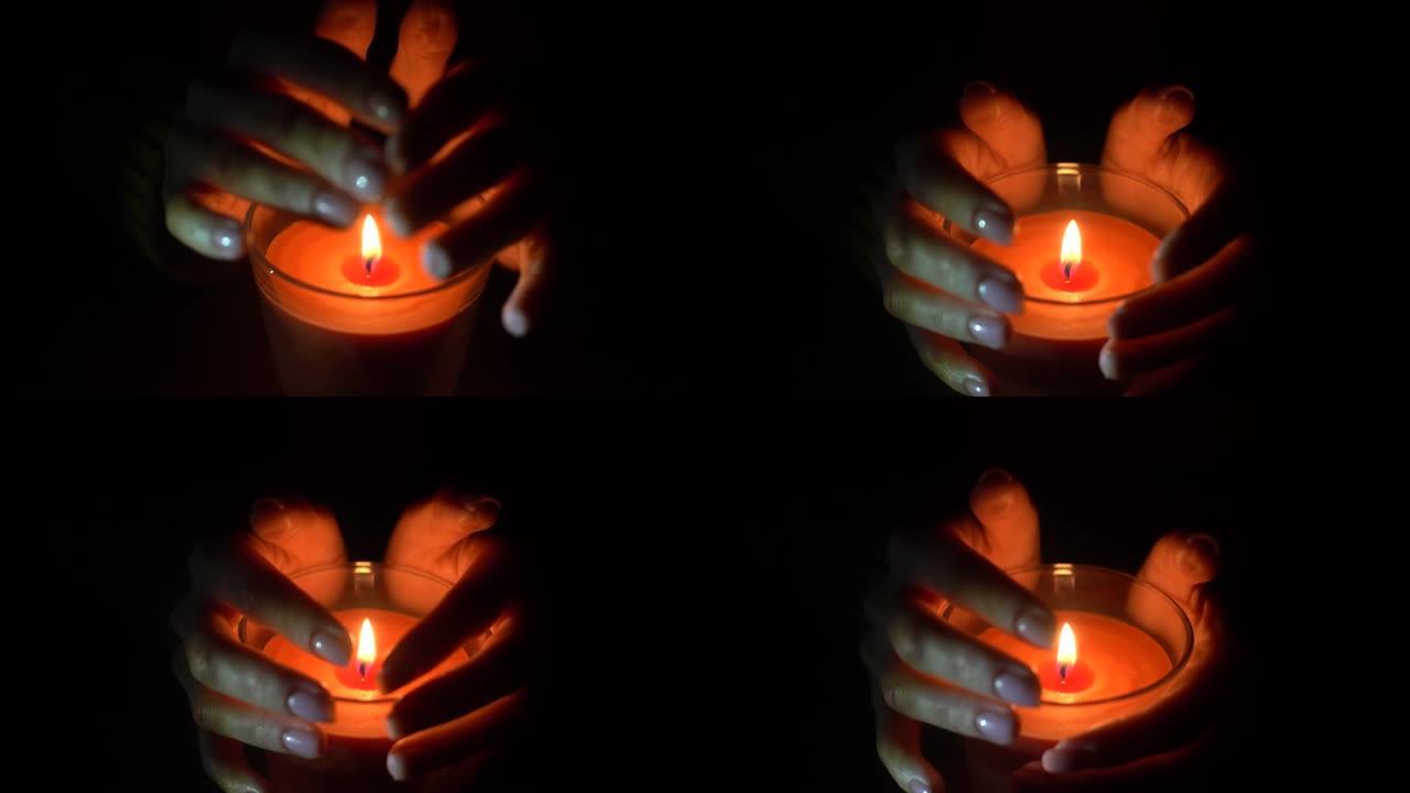女人在黑暗的夜晚在家中点燃蜡烛的特写镜头
