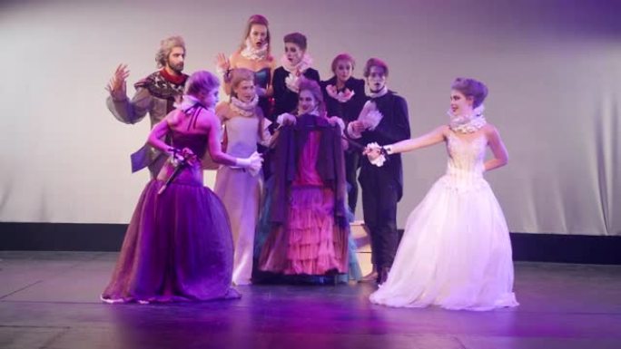 穿着公主裙模仿剑的宽镜头女演员在舞台上与演员欢呼。高加索美女在剧院扮演角色，表演现代戏剧，害怕逃跑。