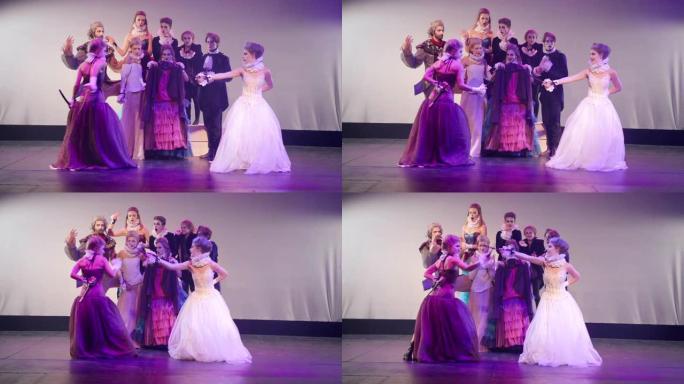 穿着公主裙模仿剑的宽镜头女演员在舞台上与演员欢呼。高加索美女在剧院扮演角色，表演现代戏剧，害怕逃跑。