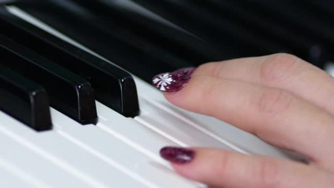 一个修指甲的女人的手的特写弹钢琴琴键。钢琴音乐课。那个女人弹合成器。音乐符号教学。选择性聚焦，浅景深