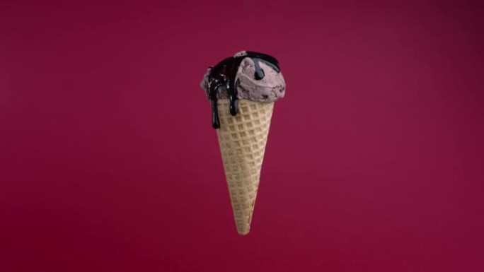 美味的巧克力冰淇淋球与糖浆浇上华夫筒在粉红色的背景