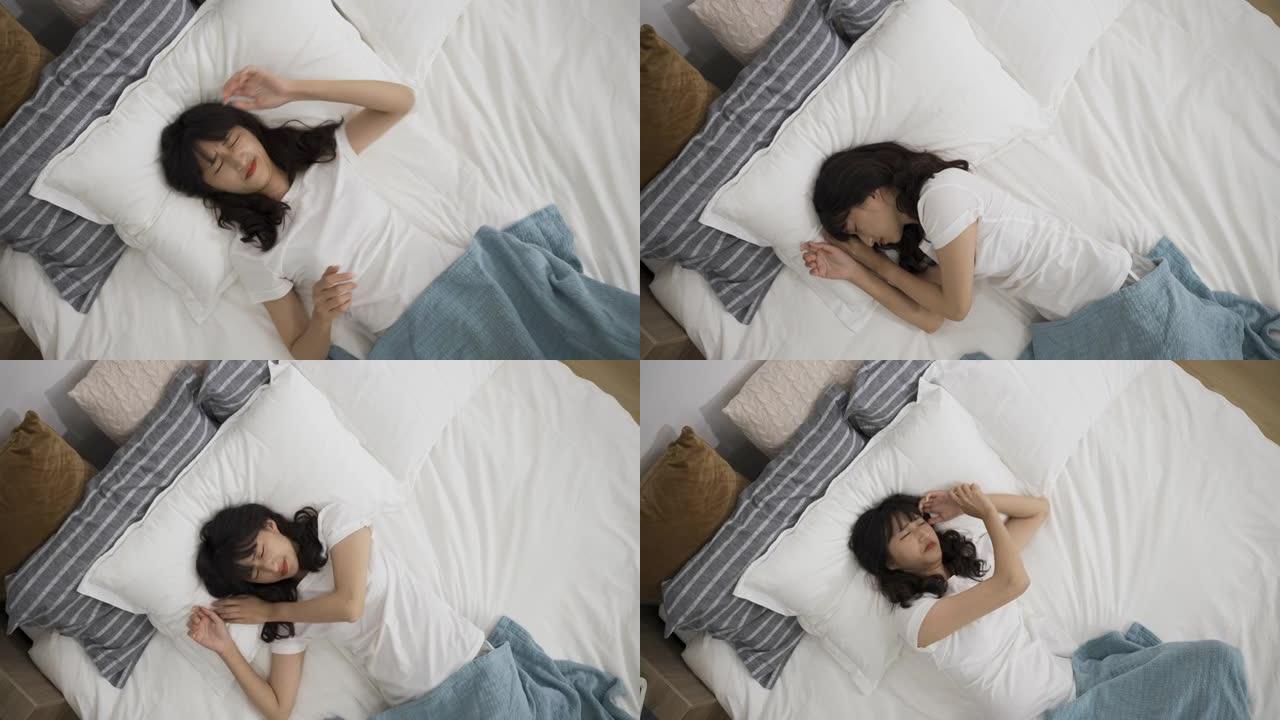 高视角缩小压力的日本女孩在午睡时间躺在床上被噩梦困扰。