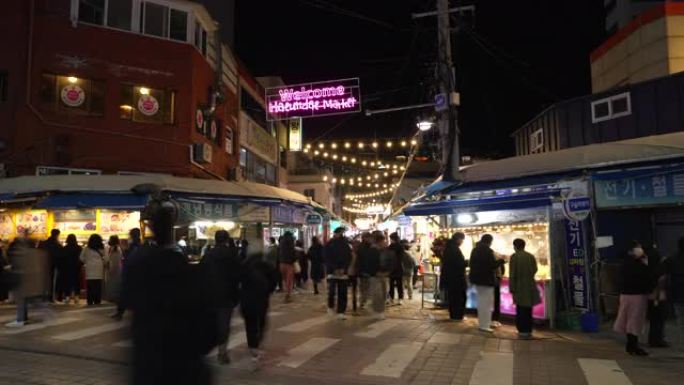 延时: 在韩国釜山海云台市场的行人和游客步行和购物