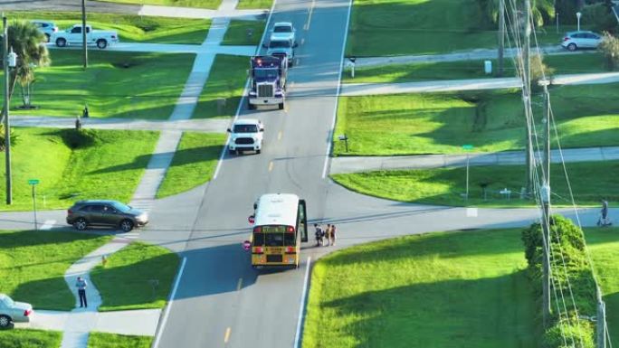 清晨，美国黄色校车在人行道上接孩子的鸟瞰图。美国的公共交通