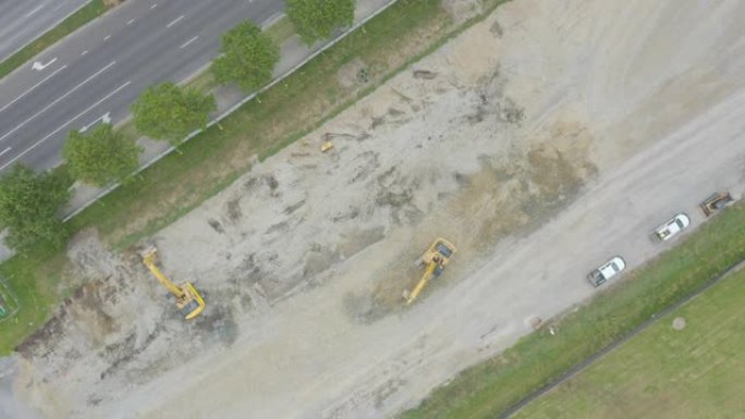光滑的空中体面俯视在空旷的建筑工地上一起工作的挖掘机。