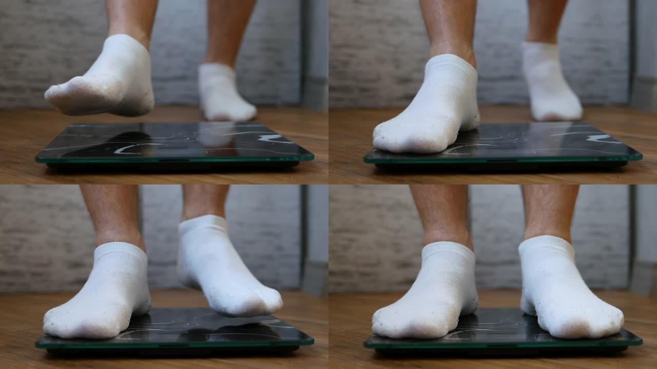 穿着白色袜子的男人的脚站在地板上。一个人在秤上称重以控制自己的体重。减肥概念。称量体重秤上的男性身体