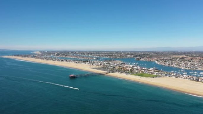 加利福尼亚州纽波特海滩巴尔博亚上空的空中飞行飞越太平洋，当船经过时，在4k面向码头