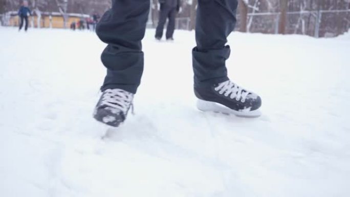 黑色溜冰鞋的特写镜头。滑冰。溜冰场。在冰雪上滚动