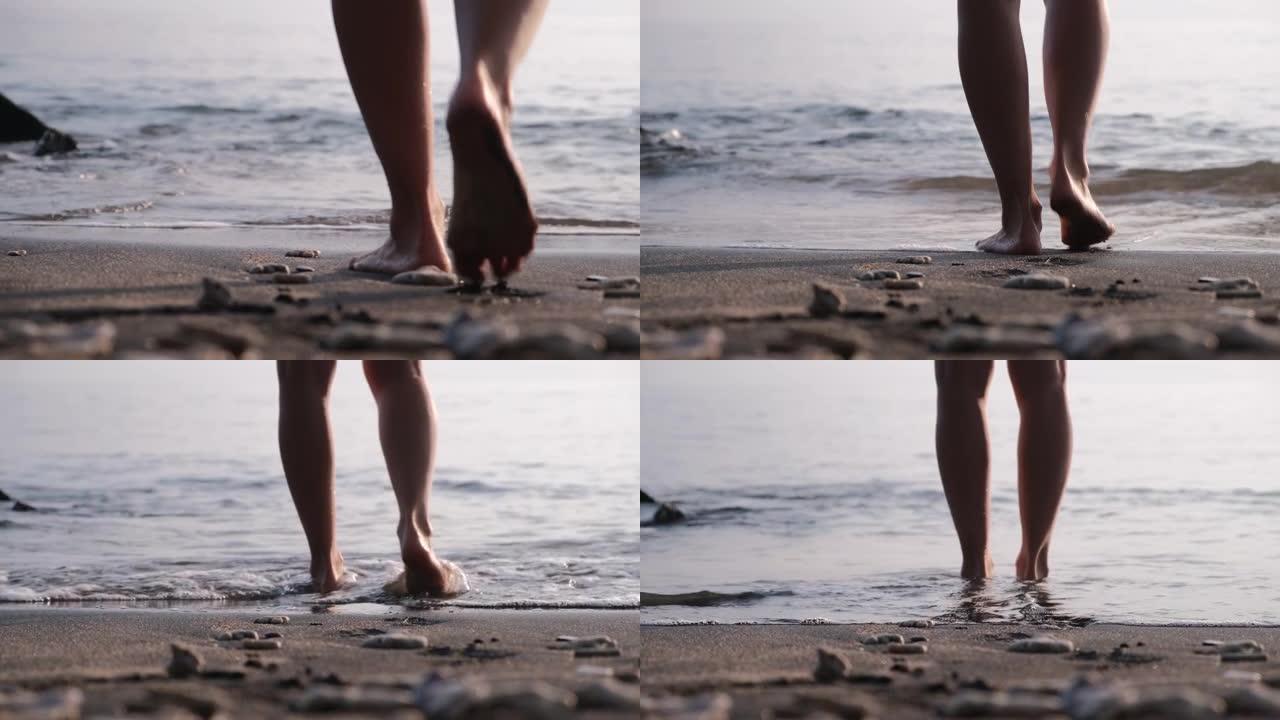 从裸露的膝盖后面射击-人类的双腿缓慢行走，朝着大海的方向测量步数，然后进入脚踝深处。这个人停下来站在