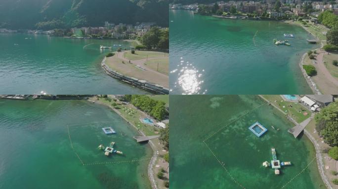 空中无人机景观沿着湖岸的海滩，人们在水中游泳