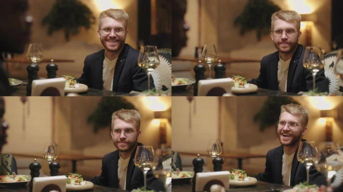 男人在餐厅玩得开心，与朋友或家人一起用餐，英俊的白人肖像