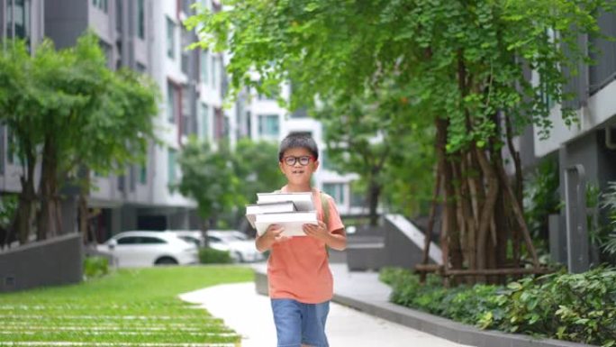亚洲学校男孩背着书上学，有创作空间和建筑。