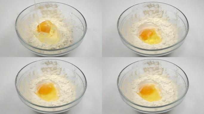 鸡蛋慢慢落入一碗面粉中，慢动作