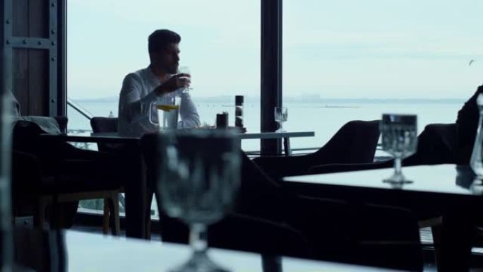具有超凡魅力的商人在豪华餐厅海景中度过午餐时间
