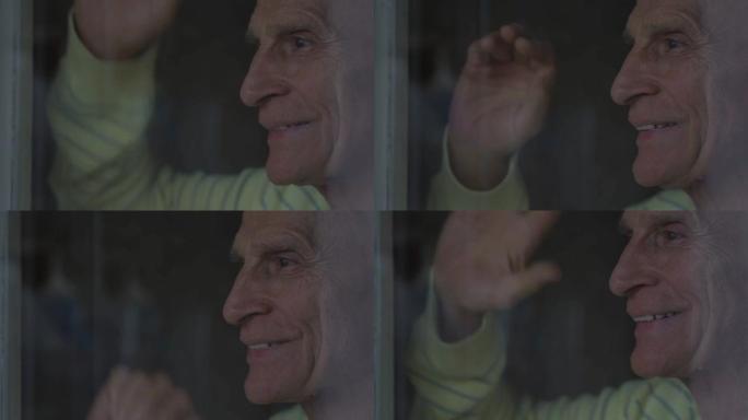 老人笑着透过窗户玻璃看着，挥手