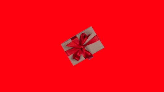 在红色背景上带有红色蝴蝶结的旋转和接近礼品盒的动画，情人节或其他假期的概念