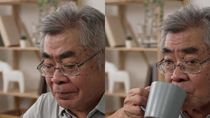 垂直屏幕: 60年代亚洲男子咳嗽，表情痛苦地按压胸部。生病的老年男性患者在餐桌上有药物和水杯以预防c