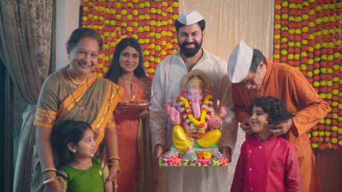 快乐的印度民族家庭在Ganesha Chaturthi庆祝活动上看着相机。